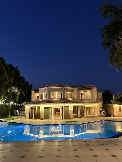 واجهة Casa De Palm المضاءة مساءً مع انعكاس المبنى في المسبح